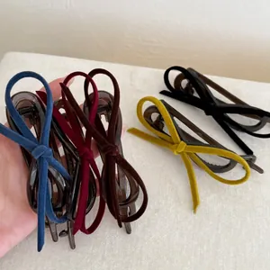 Detailed view of five colors of vintage velvet bow banana clips with textured finish