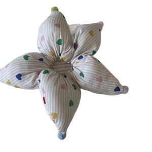 Plush flower scrunchie with striped patterns, multicolor hearts and colorful pom-poms