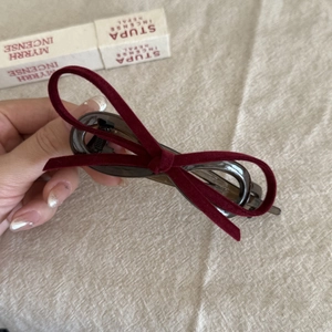 Close-up of wine red velvet bow hair clip with dark grey translucent resin texture