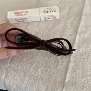 Detail of a brown velvet bow hair clip with a vintage flocked texture for women