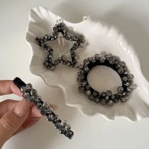 Detailed close-up of handmade grey beaded star hair clip and scrunchie set