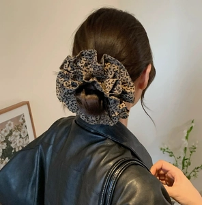 Detail of vintage leopard print scrunchie worn in hair with textured pleats and silk fabric