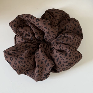 Macro detail of oversized vintage leopard print scrunchie with rich fabric folds