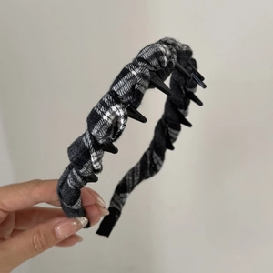 Detailed view of vintage black and white plaid fabric headband with non-slip inner teeth