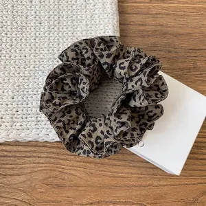 Detail view of a vintage leopard print scrunchie on a cozy aesthetic surface