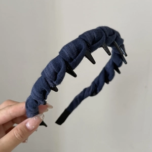 Detailed macro view of navy blue pleated fabric headband with non-slip inner plastic teeth