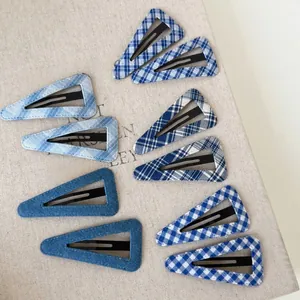 Flat lay of 10-piece triangle hair clips set with blue denim and plaid fabric textures