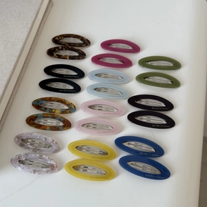 Vue détaillée d'un lot de 20 barrettes ovales en acétate aux motifs marbrés colorés