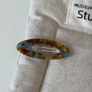 Vue détaillée de la barrette ovale en acétate avec motif écaille marron et bleu