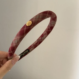 Red plaid headband with vintage golden metal label and classic minimalist design for women