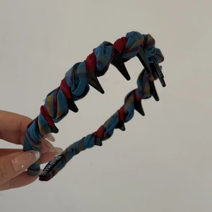 Detail of red and blue plaid fabric headband with non-slip teeth and handmade label