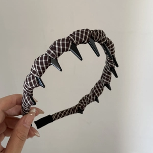 Detail view of the brown plaid fabric headband with black non-slip inner teeth