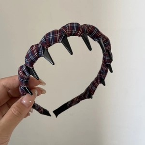 Detailed macro view of the classic plaid fabric texture and black anti-slip teeth on the headband
