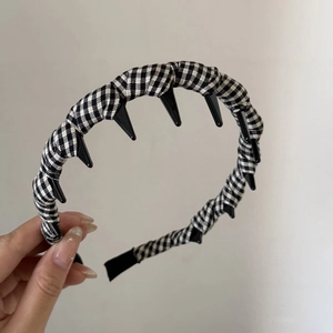 Detail of vintage plaid fabric headband with black non-slip plastic teeth for hair styling