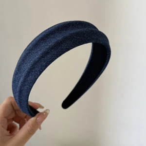 Detail shot of navy blue denim headband showing the textured fabric and wide padded structure