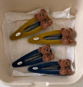 Detail of cute flocked bear hair clips in yellow and blue with Love metal tag