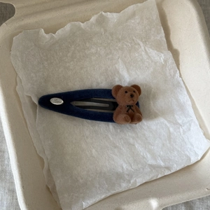 Detail of navy flocked snap hair clip featuring a cute brown bear doll and Love engraving