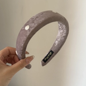 Detailed close-up of velvet polka dot headband with internal logo label detail