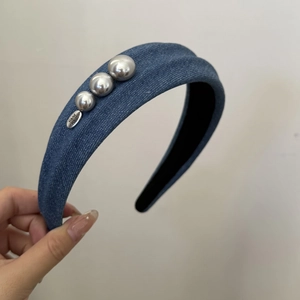 Nahaufnahme von blauem Denim-Haarreif mit silbernen Perlen und Hand-made-Metallanhänger