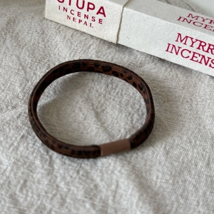 Gros plan d'un élastique à cheveux imprimé léopard sur tissu en lin avec lumière douce