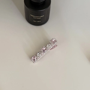 Détail d'une barrette en cristal rose avec base en alliage poli et strass