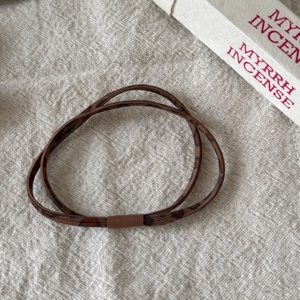 Détail d'un élastique à cheveux imprimé léopard marron foncé avec fermeture mate de qualité