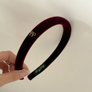 Elegant wine red velvet headband with a delicate gold bow accessory for a vintage look