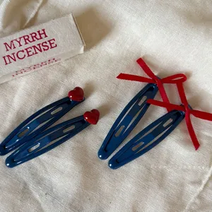 Navy blue BB hair clips with red heart and ribbon bow accents for women and girls