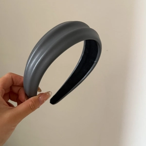 Détail d'un serre-tête épais en cuir PU gris avec doublure intérieure noire antidérapante