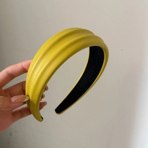 Détail du serre-tête en cuir PU jaune avec trois rayures texturées parallèles en relief