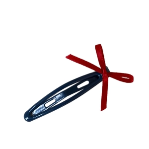 Navy blue snap hair clip with a bright red silk bow decoration on white background
