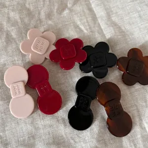 Floral and bow acetate hair clips in pink red and tortoiseshell patterns on linen