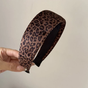 Gros plan détaillé du serre-tête léopard montrant la texture velours et la doublure noire