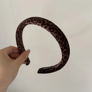 Détail d'un serre-tête rembourré fait main avec motif léopard et étiquette intérieure