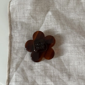 Detail of tortoiseshell flower hair clip made of acetic acid with WET WET engraved text