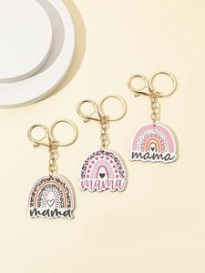 Detail van drie regenboogvormige mama-sleutelhangers met luipaardprint en gouden sluiting