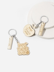Detail of laser-engraved wood apple keychain and ruler with best teacher ever text