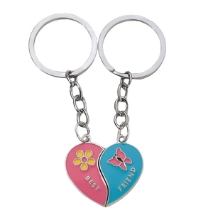 Pink and blue heart-shaped Best Friend keychain set with enamel floral and butterfly patterns