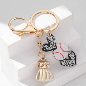 Leopard print heart keychain with baseball charm and cream tassel on gold lobster clasp