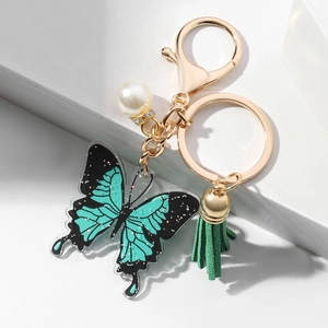 Teal and black acrylic butterfly keychain with glitter, gold metal clasp and green tassel