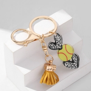 Detail of yellow softball acrylic keychain with leopard heart charms and gold ring