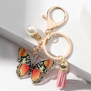 Detail of acrylic butterfly keychain with pink leather tassel and white faux pearl accent
