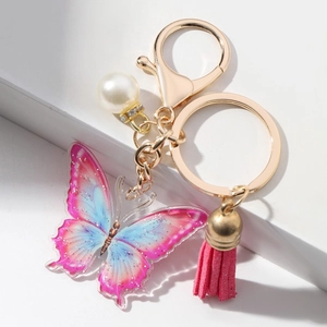 Detailed macro view of colorful butterfly keychain with pink tassel and pearl charm
