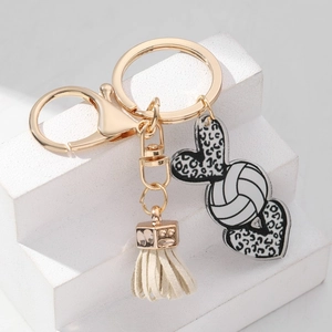 Detail of volleyball acrylic keychain with leopard heart charms and cream tassel