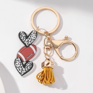 Close-up of leopard print hearts and rugby acrylic keychain with yellow tassel