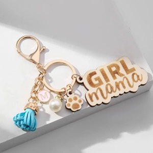 Detail of wooden GIRL MAMA keychain with blue tassel, pink M pendant and pearl bead