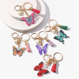Colorful acrylic butterfly keychains with soft tassels and pearls on gold rings