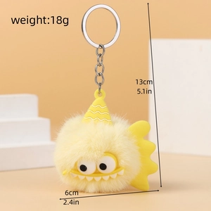 Close-up of yellow monster plush keychain showing soft texture and silver keyring
