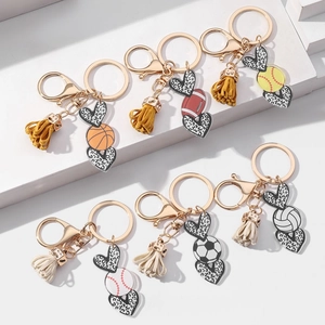 Close-up of leopard heart keychains with sports ball charms and colorful suede tassels