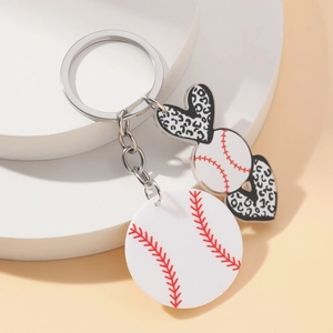 Leopard print heart and baseball keychain with silver ring on minimalist display stand